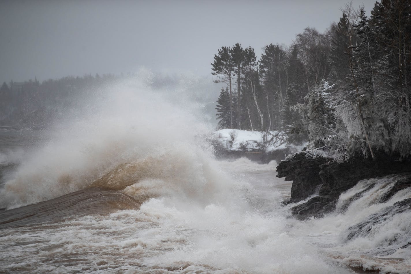 Large waves from Lake Superior beat against a snow covered shoreline in Two Harbors, MN on Wednesday morning. ]