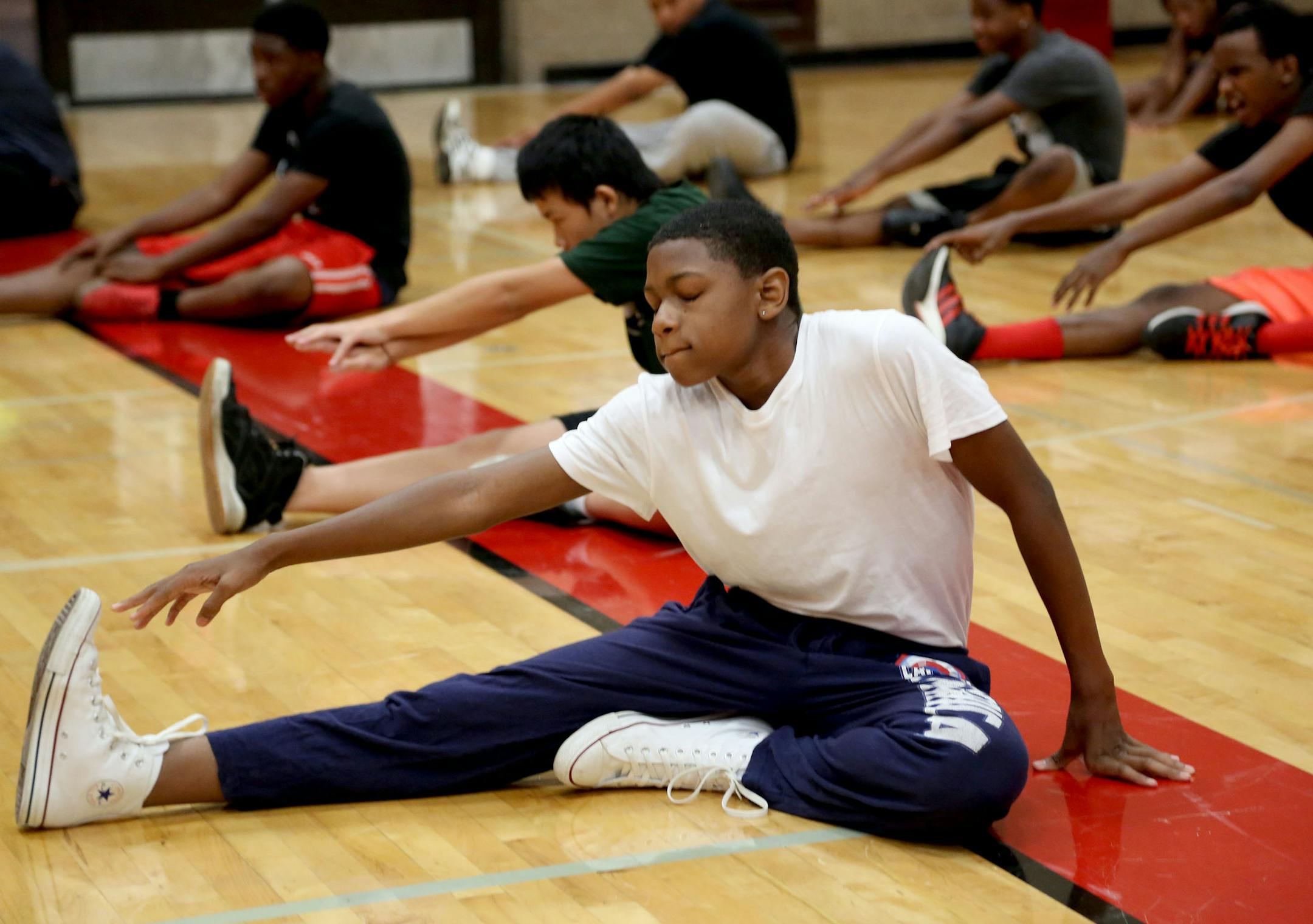 Semaj Moore Rankin, 14, reached to touch his toes during class warm ups. ] (KYNDELL HARKNESS/STAR TRIBUNE) kyndell.harkness@startribune.com During 9th grade physical education classMinneapolis Min., Friday, August, 5, 2014.