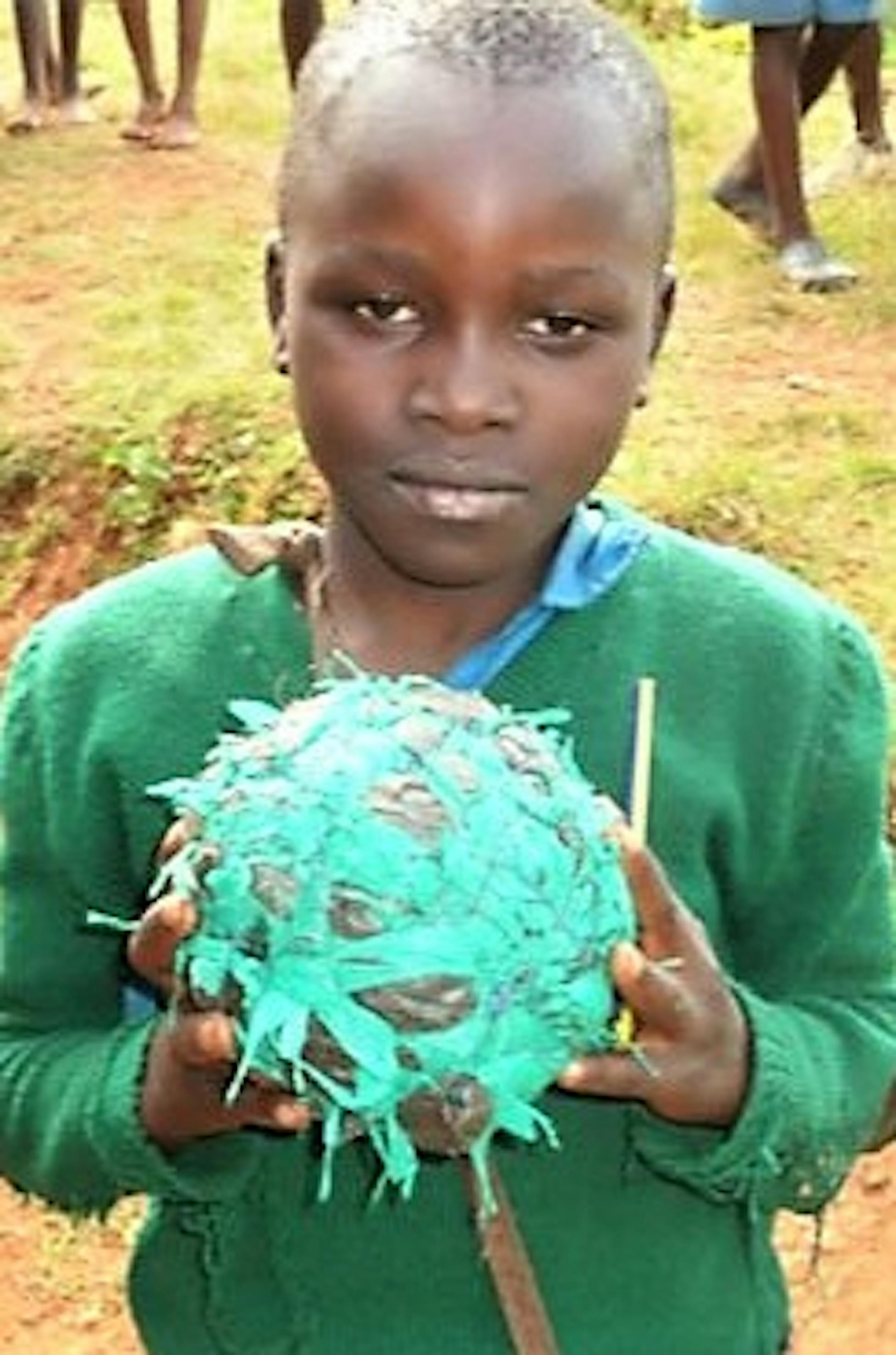 A young Tanzanian holds a makeshift basketball