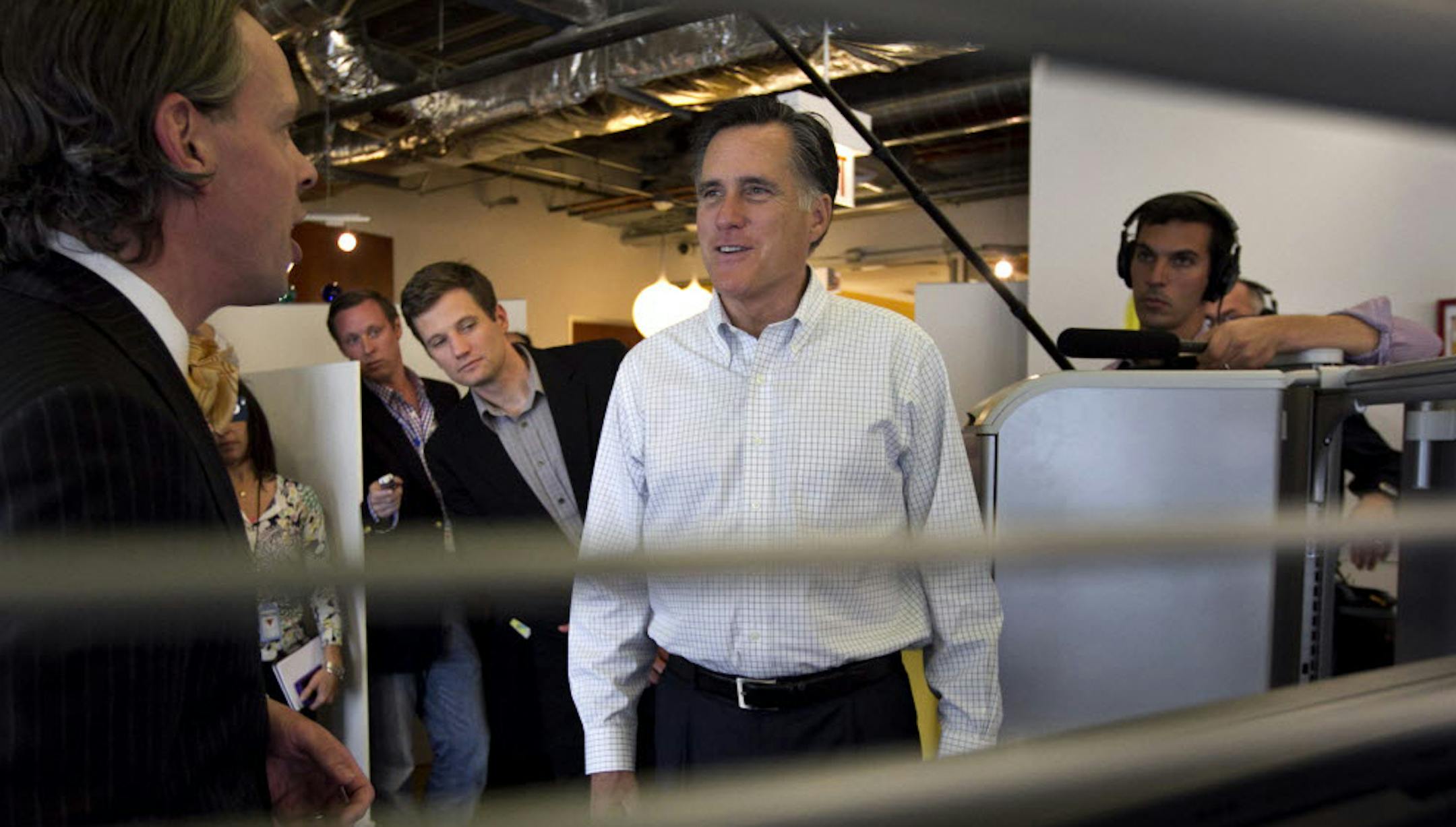 Mitt Romney, center, speaks with Google employee Ted Souder, left, at the Chicago Google headquarters, in Chicago, Tuesday.