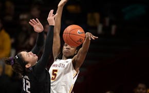 Gophers forward Taiye Bello (5) blocked the shot of Northwestern's Veronica Burton during Minnesota's 73-64 overtime victory at Williams Arena on Sund