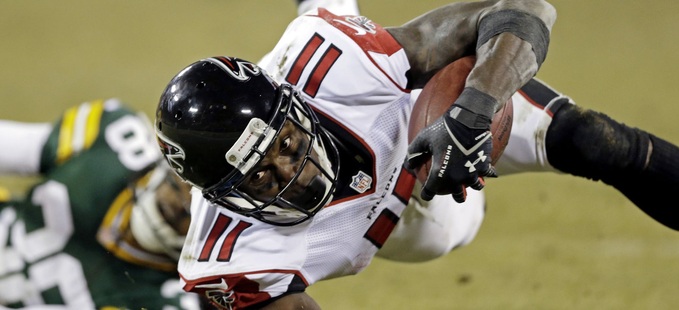 FILE - In this Dec. 8, 2014, file photo, Atlanta Falcons' Julio Jones is tripped up by Green Bay Packers' Tramon Williams after a catch during an NFL football game in Green Bay, Wis. Jones, who set career highs with 104 catches for 1,593 yards last year, is entering the final year of his contract. (AP Photo/Tom Lynn, File)