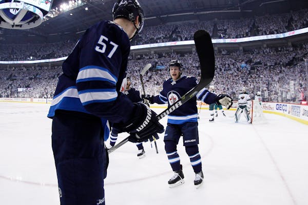 Winnipeg Jets' Tyler Myers (57) and Andrew Copp (9) celebrate Myers' goal against the Wild during the second period of Game 2