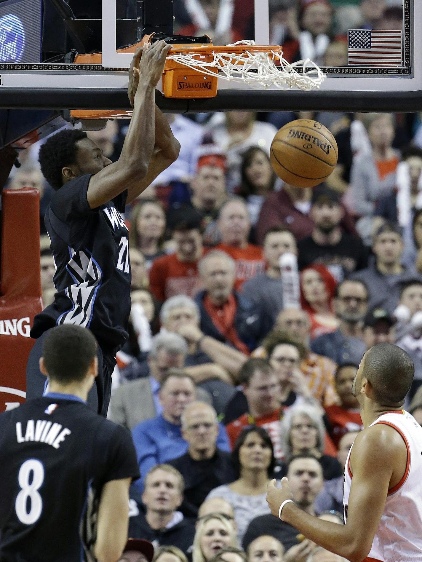 Minnesota Timberwolves forward Andrew Wiggins, left, scores over Portland Trail Blazers forward Nicolas Batum, from France, during the first half of an NBA basketball game in Portland, Ore., Wednesday, April 8, 2015. (AP Photo/Don Ryan)