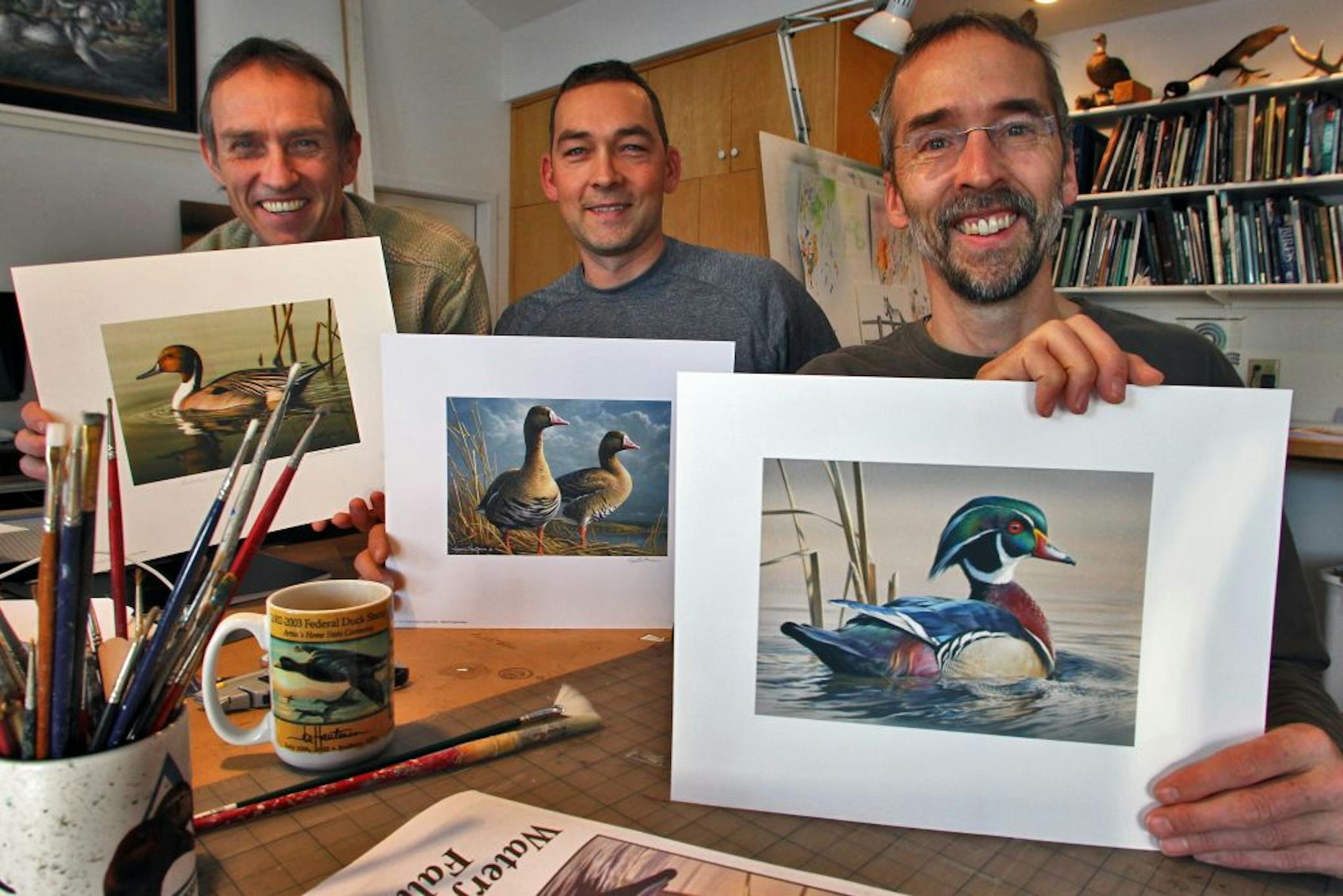 Brothers Joe, Bob and Jim Hautman have won the Federal Duck Stamp contest 10 times, with Joe the current recipient of the award. Here Bob Hautman, left,displayed his 2001 print winner, Jim Hautman, center, displayed his 2011 print winner, while Joe Hautman, right, displayed his 2012 print winner.