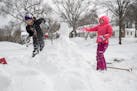 Nine-year-old twins Chrissy and C.J. Burkhart had a snowball fight as they made an igloo in their yard when school was canceled because of the snow on