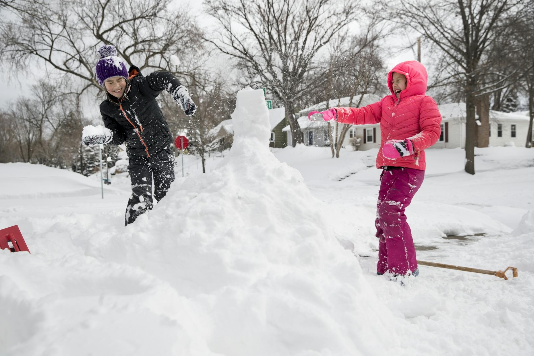 Nine-year-old twins Chrissy and C.J. Burkhart had a snowball fight as they made an igloo in their yard when school was canceled because of the snow on Monday, April 16, 2018 in Minneapolis, Minn.