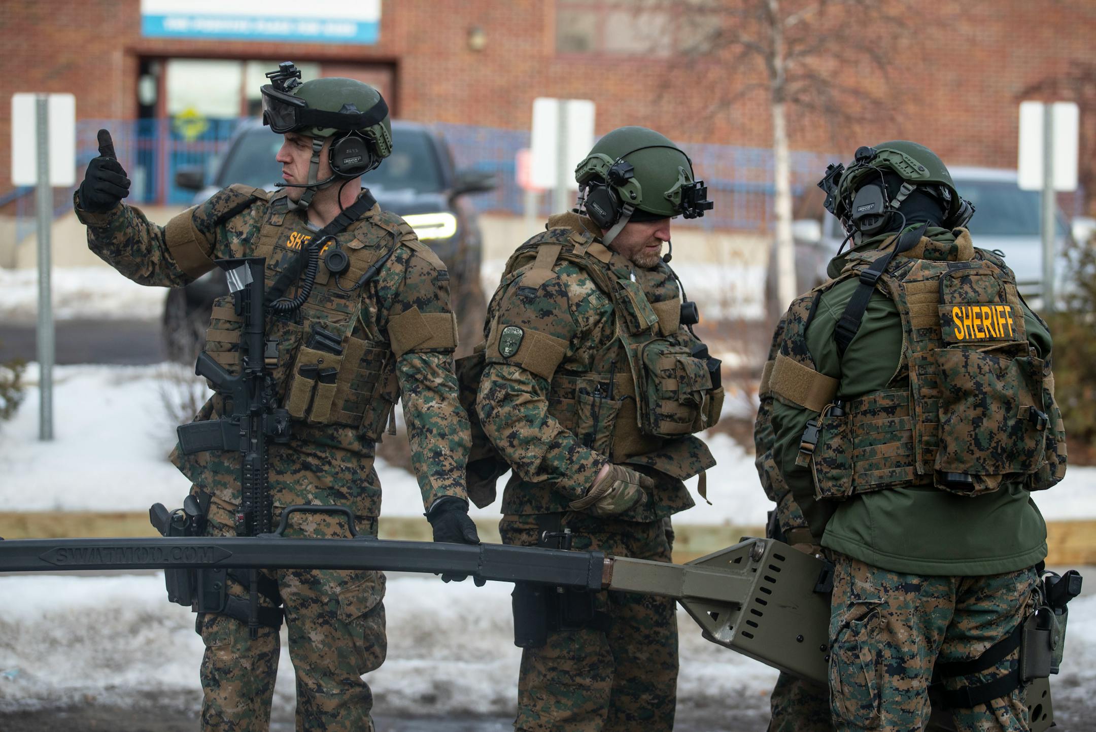 St. Louis County Sheriff officers worked on assembling a device to launch non-lethal smoke grenades into the gunman's home from the safety of their armored vehicle.