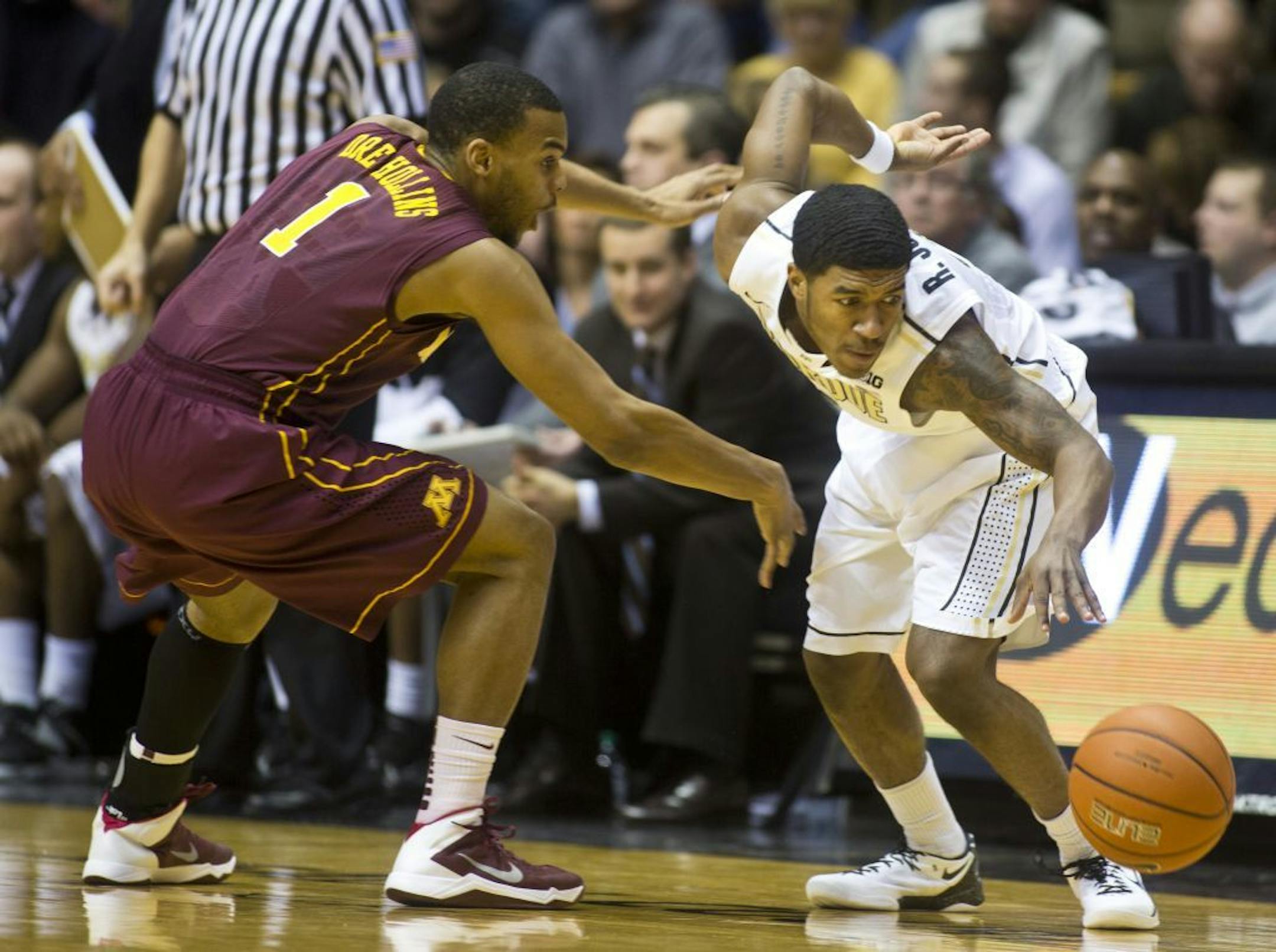Minnesota's Andre Hollins, left, has the ball knocked out of his hands by Purdue's Ronnie Johnson during an NCAA college basketball game Wednesday, Feb. 5, 2014, at Mackey Arena in West Lafayette, Ind. (AP Photo/Journal & Courier, Michael Heinz) NO SALES