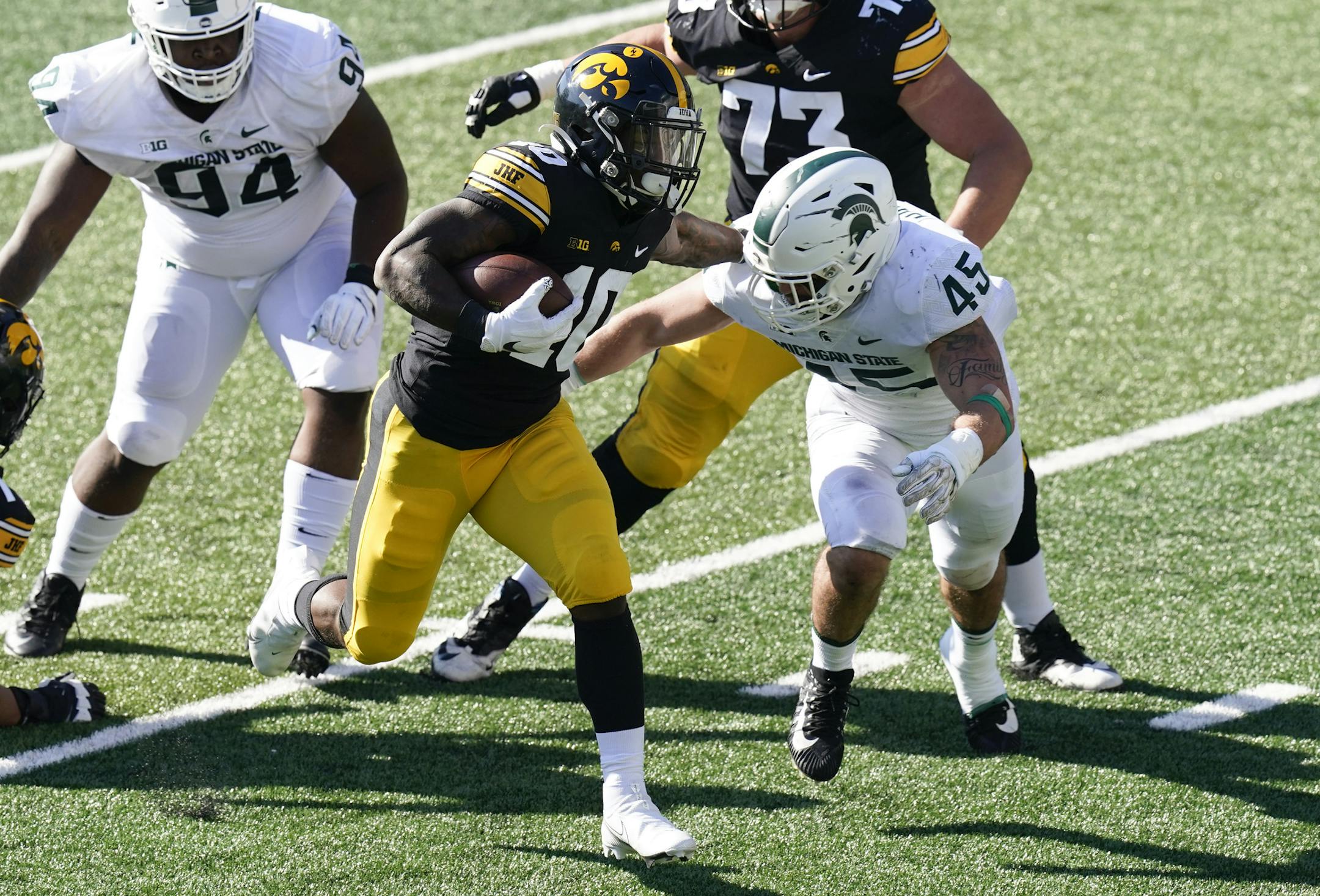Iowa running back Mekhi Sargent (10) runs from Michigan State linebacker Noah Harvey (45) during the first half of an NCAA college football game, Saturday, Nov. 7, 2020, in Iowa City, Iowa. (AP Photo/Charlie Neibergall) ORG XMIT: IACN106