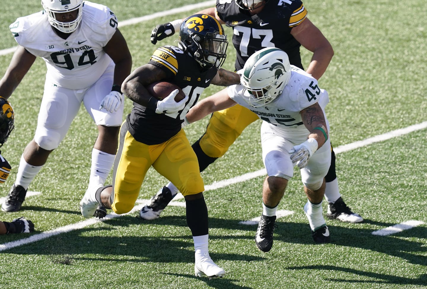 Iowa running back Mekhi Sargent (10) runs from Michigan State linebacker Noah Harvey (45) during the first half of an NCAA college football game, Saturday, Nov. 7, 2020, in Iowa City, Iowa. (AP Photo/Charlie Neibergall) ORG XMIT: IACN106