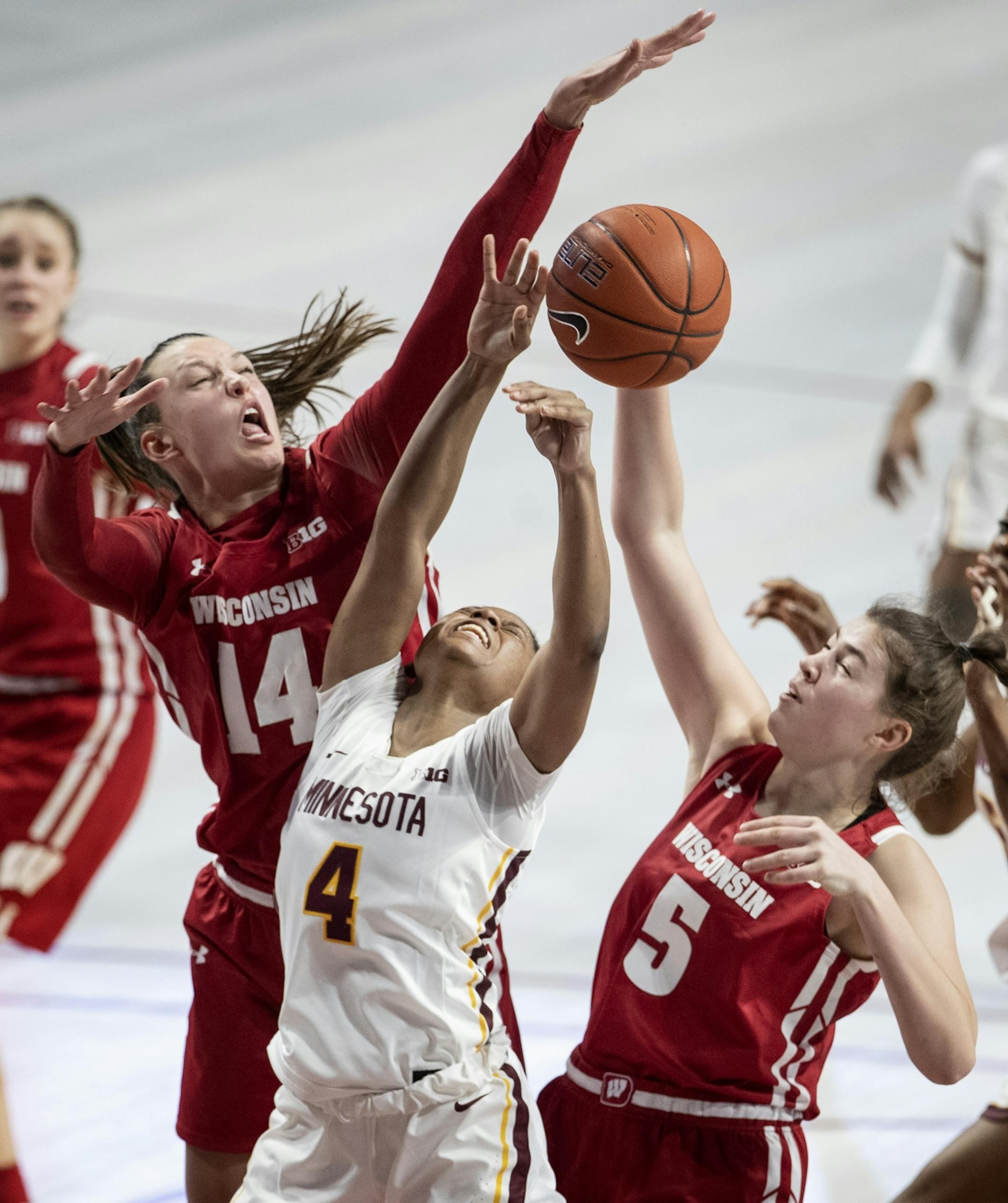 Abby Laszewski (14) and Julie Pospisilova (5) of Wisconsin blocked a shot by Jasmine Powell (4) of Minnesota in the third quarter.