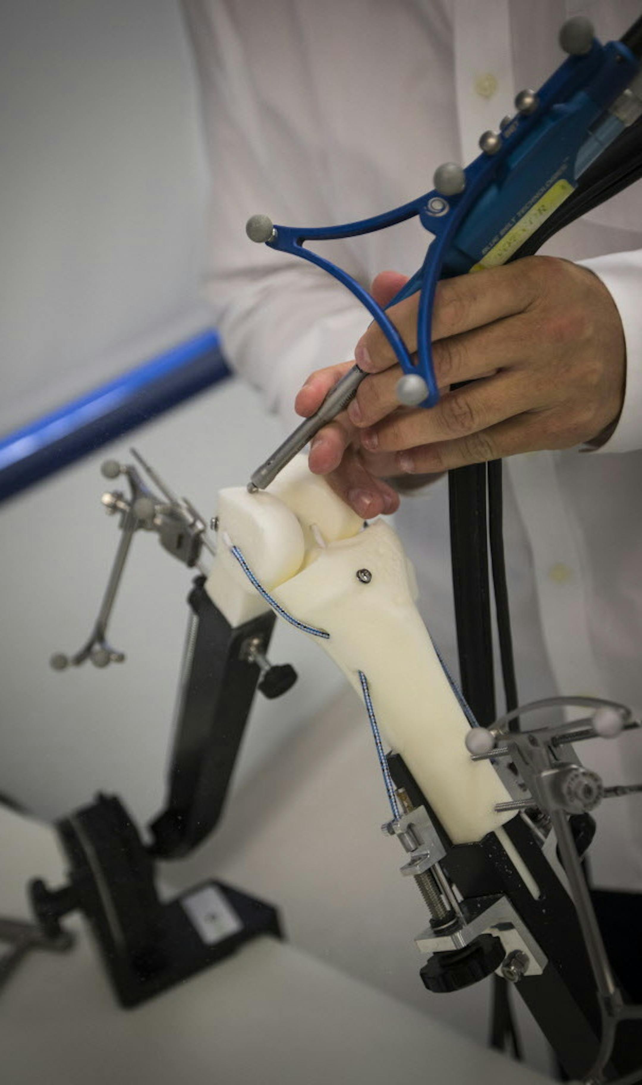 Blue Belt Technologies territory manager Chad Krueger demonstrated how to use their robotically controlled surgical system that gives doctors enough precision to confidently do partial-knee surgeries. The tool, called a Navio Surgical System, is connected to a video camera that indicates precisely by color coding on the screens where to drill into the bone. Photographed at Blue Belt Technologies in Plymouth, Minn., on Monday, July 27, 2015. ] RENEE JONES SCHNEIDER &#x2022; reneejones@startribune