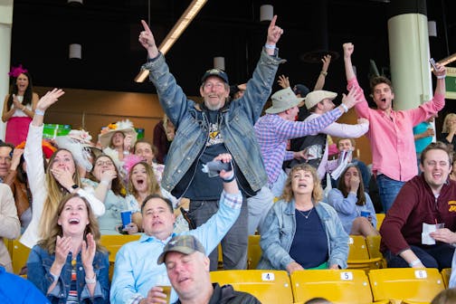 Racing fans react while watching the finish of the 149th Kentucky Derby.