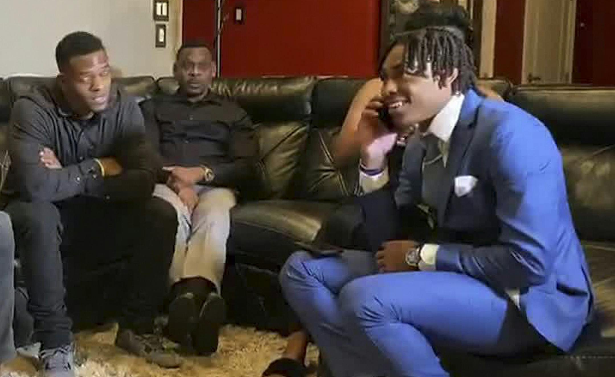 Justin Jefferson, right, smiles while watching the NFL football draft at home in Louisiana.