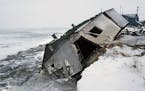 FILE - In this Dec. 8, 2006, file photo, Nathan Weyiouanna's abandoned house at the west end of Shishmaref, Alaska, sits on the beach after sliding of