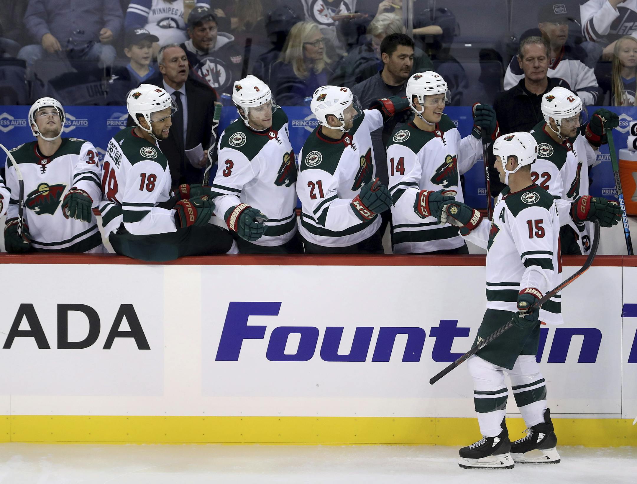 Former Winnipeg Jets player and current Minnesota Wild player Matt Hendricks (15) celebrates after scoring during third-period preseason NHL hockey game action in Winnipeg, Manitoba, Monday, Sept. 17, 2018. (Trevor Hagan/The Canadian Press via AP)