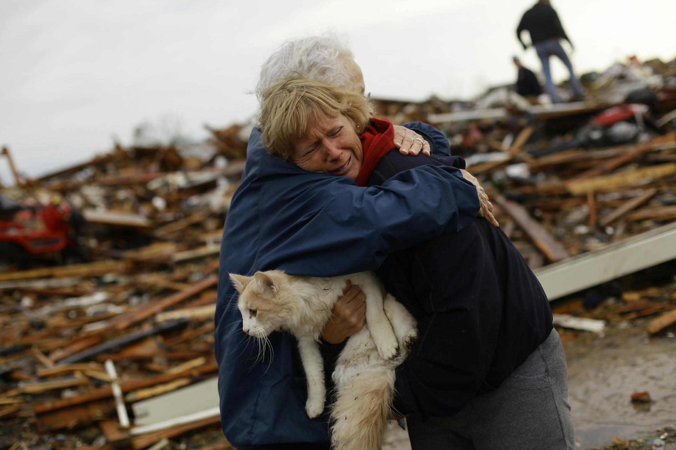 June Simson (R) receives a hug from her neighbor Jo McGee while embracing her cat Sammi after she found him standing on the rubble of her destroyed home on May 21, 2013 in Moore, Oklahoma.