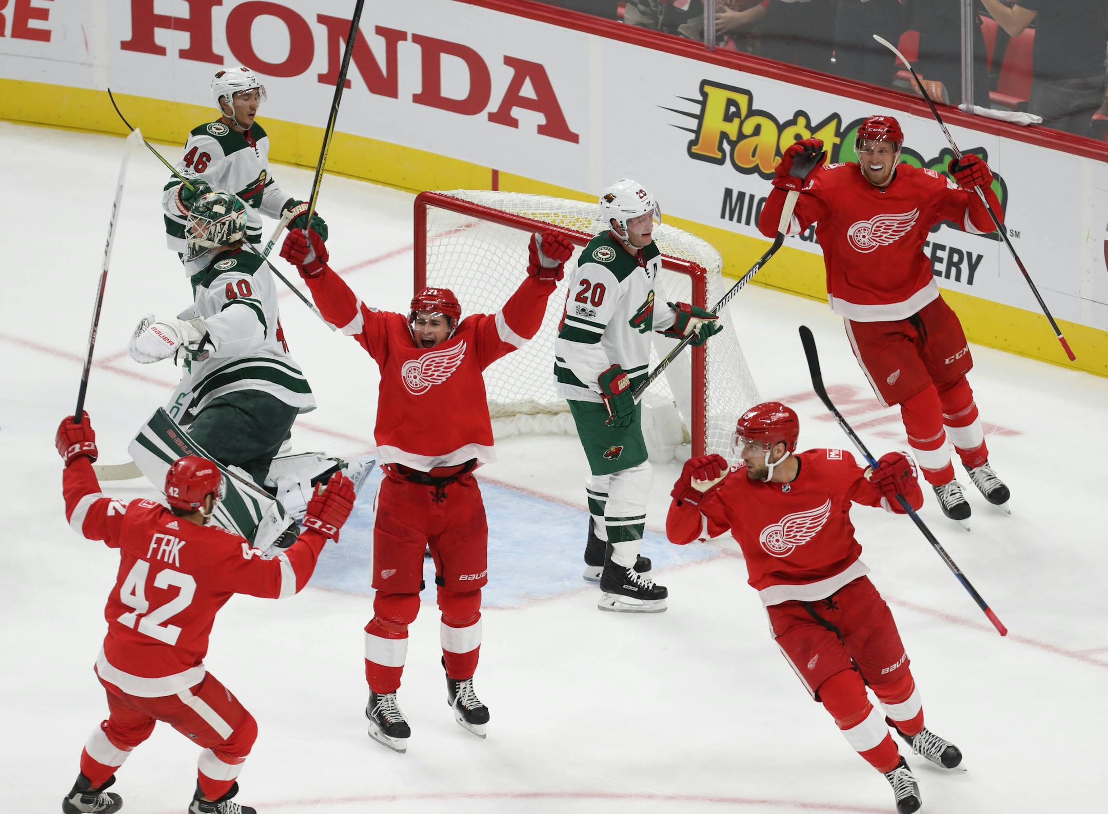 The Red Wings' Dylan Larkin and teammates celebrated a goal against Wild goalie Devan Dubnyk during the second period at Little Caesars Arena in Detroit on Thursday.