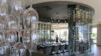 Restaurant review, - Lela, - Interior, a divider of wine glasses seperates the bar area and the dining room, with a group table situated inside see-th