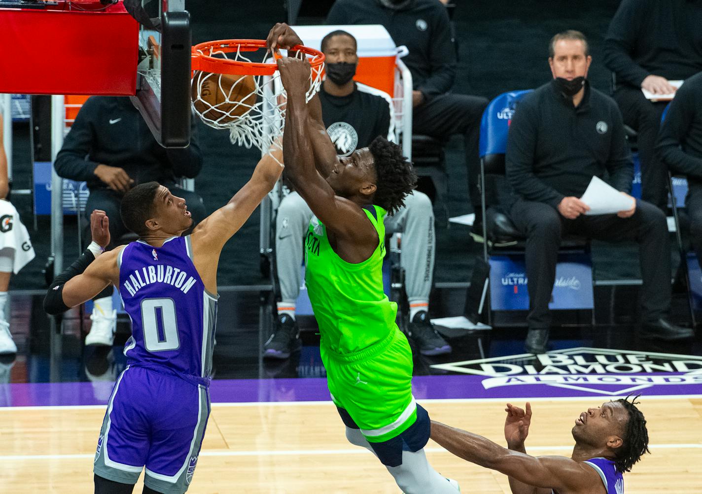 Timberwolves forward Anthony Edwards dunks as Kings guard Tyrese Haliburton defends during the first quarter