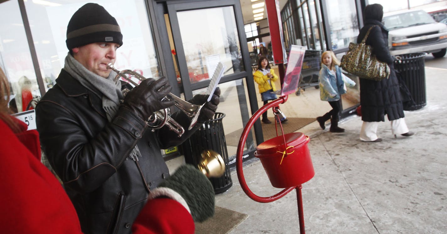 DAVID JOLES &#x201a;&#xc4;&#xa2; djoles@startribune.com - Dec. 18, 2010-Eden Prairie, MN-] A Salvation Army bell ringer who grew up playing in the Salvation Army band, Erik Sundman credits with the Salvation Army introducing him to the two loves of his life, music and his wife Lynnea (he met her at Salvation Army camp). Now a professional musician, Sundman and his wife are committed to give back by sharing his music as a volunteer at holiday time and year round. In this photo:] As Lynnea rang th