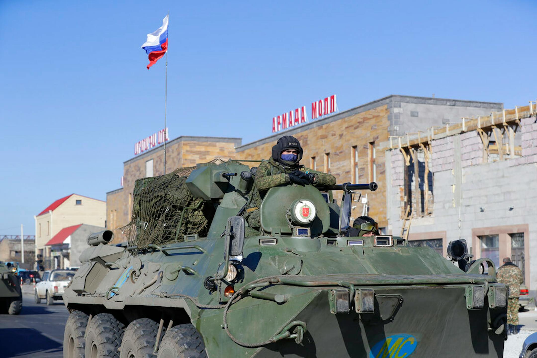 Russian military vehicles roll along a road in Martuni, Armenia, towards the separatist region of Nagorno-Karabakh, Friday, Nov. 13, 2020.
