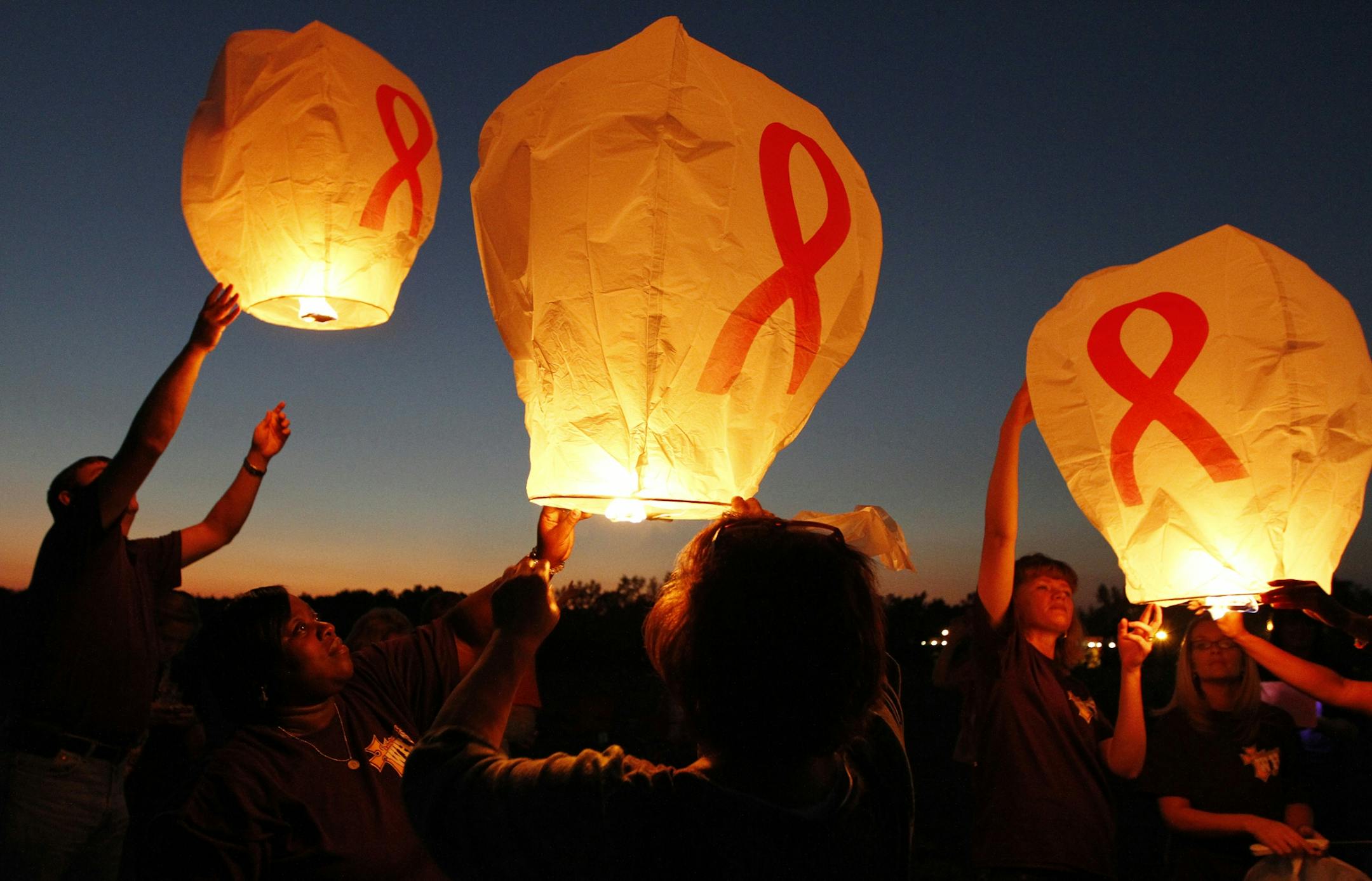Volunteers with the Women's Health Center release skylanterns to promote breast cancer awareness at the New Heights Baptist Church in Summit, Miss.