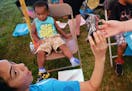 From left, Volunteer Maria Lopez, of Blaine, reacted to the new shoe she was being handed for Eugene Terry, 2, of Fridley, during Convoy of Hope at Sp