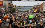 In this photo taken Tuesday, Aug. 4, 2015, hundreds of people gather for the official 75th Sturgis motorcycle rally photo on Main Street in Sturgis S.