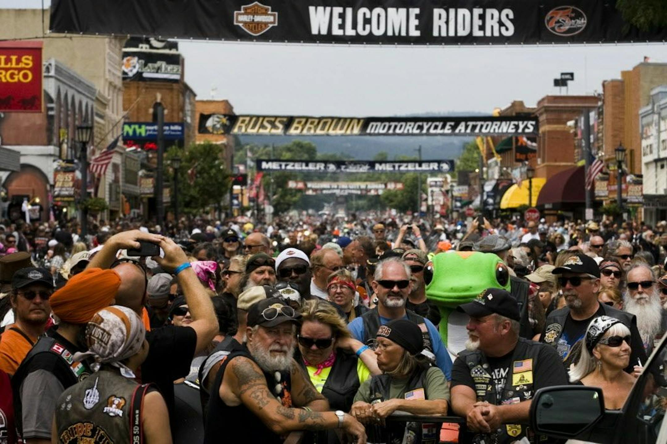 In this photo taken Tuesday, Aug. 4, 2015, hundreds of people gather for the official 75th Sturgis motorcycle rally photo on Main Street in Sturgis S.D.
