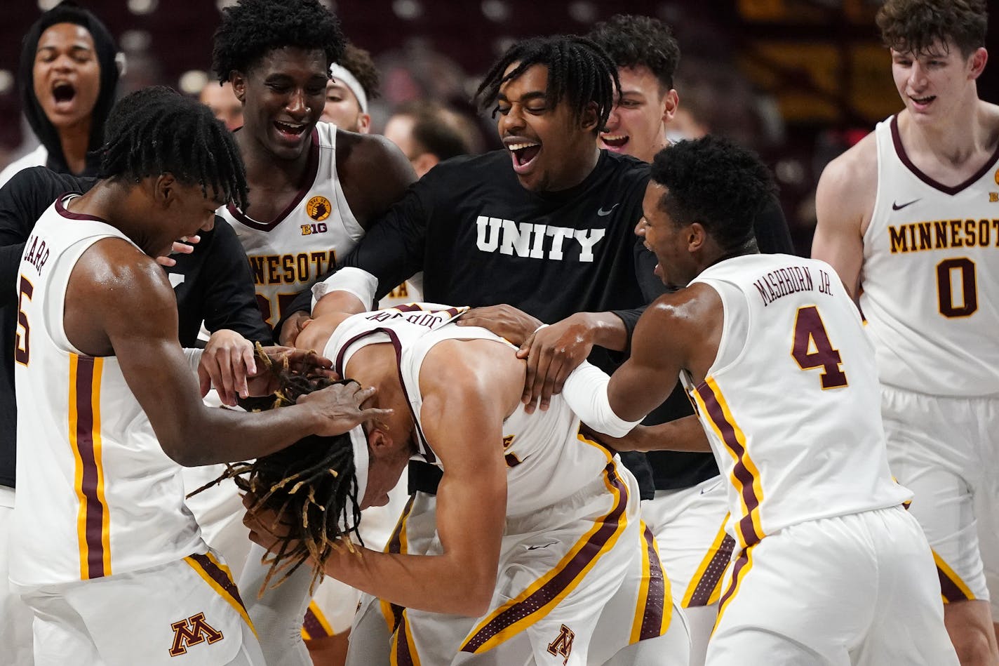 Minnesota forward Brandon Johnson (23) was mobbed by his teammates on the court after his multiple three point shots helped them beat the Iowa Hawkeyes 102-95 in overtime Friday. ] ANTHONY SOUFFLE • anthony.souffle@startribune.com