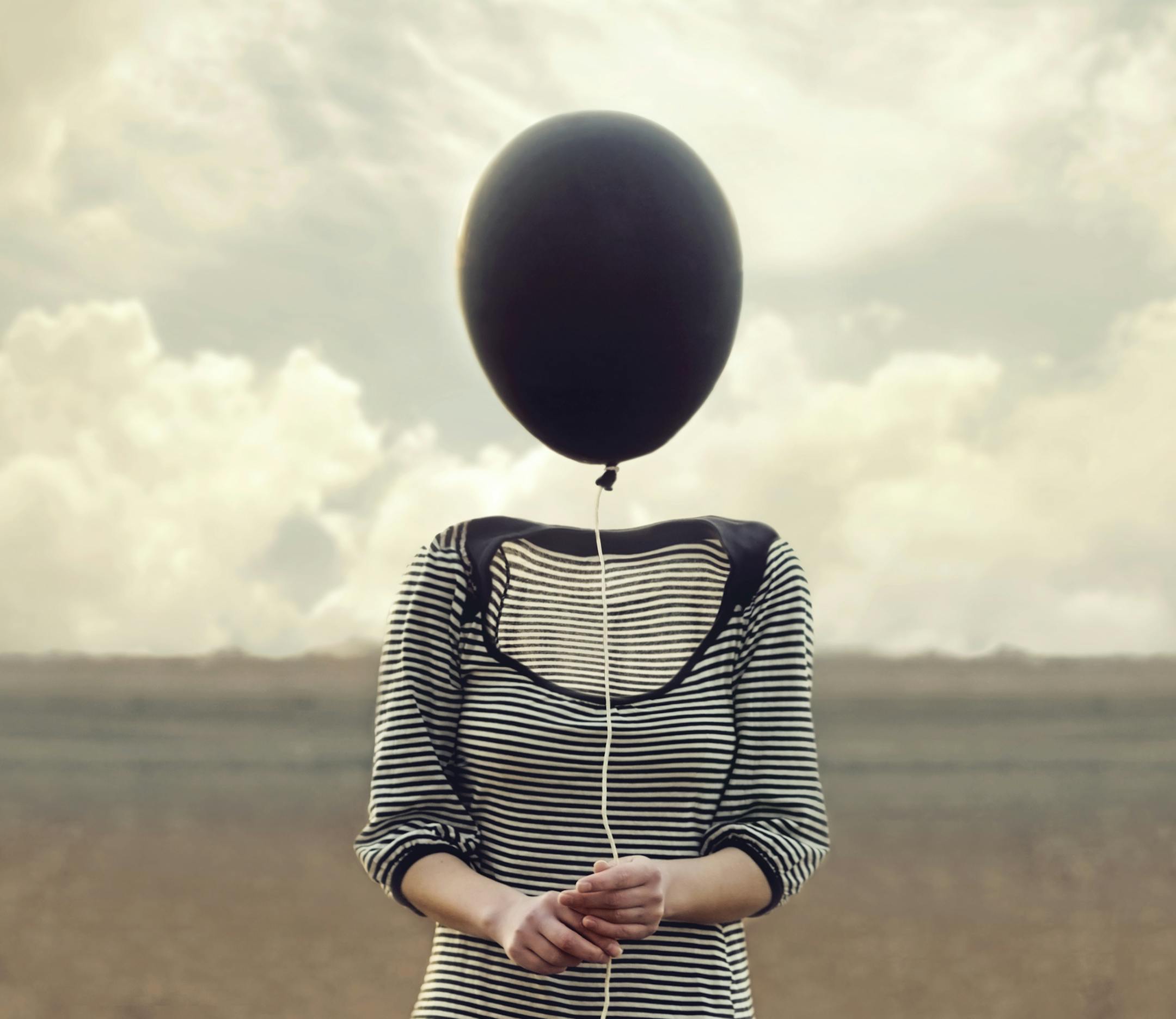 woman's head replaced by a black balloon