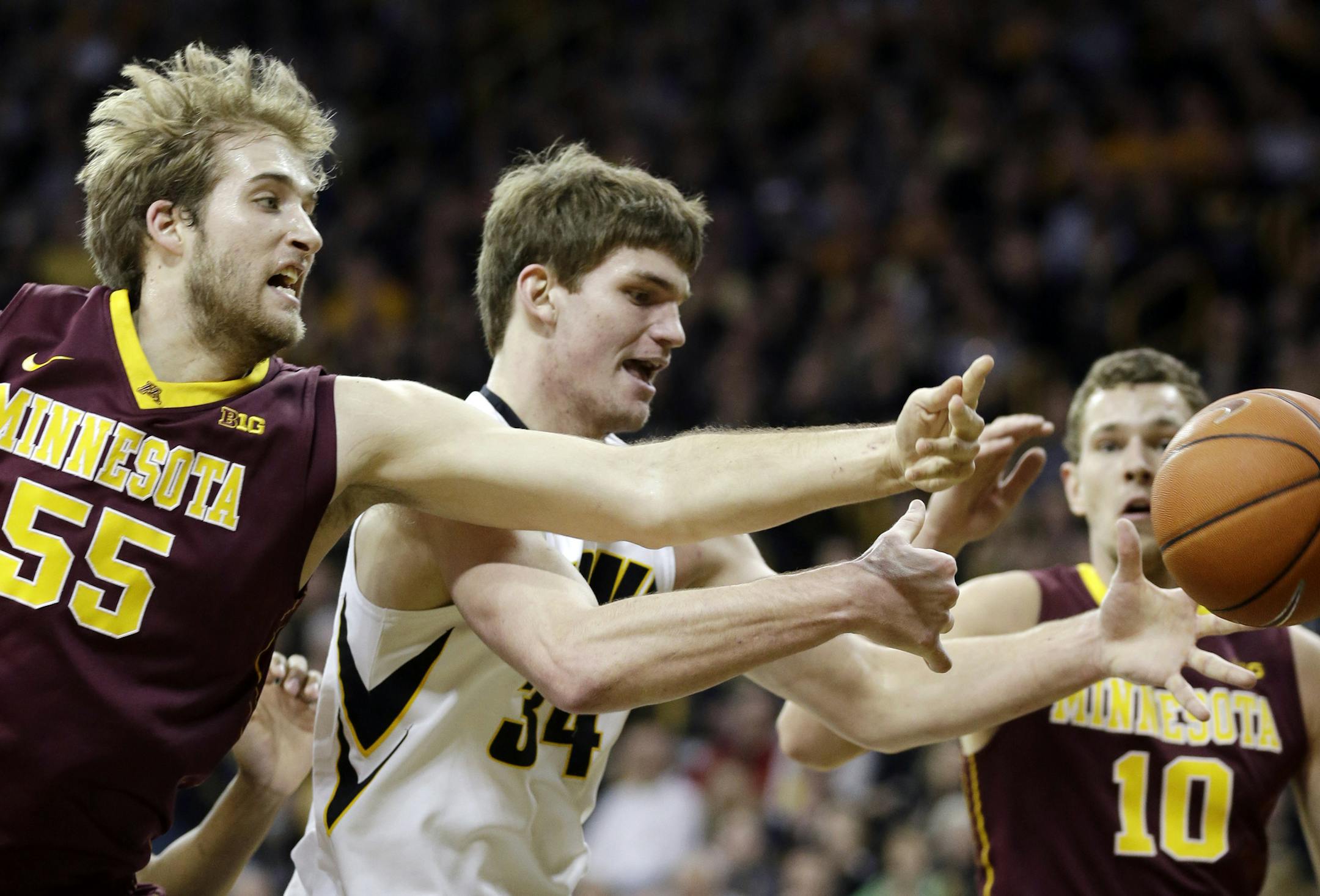Iowa center Adam Woodbury, center, fought for a rebound with the Gophers' Elliott Eliason, left, and Oto Osenieks during the first half.