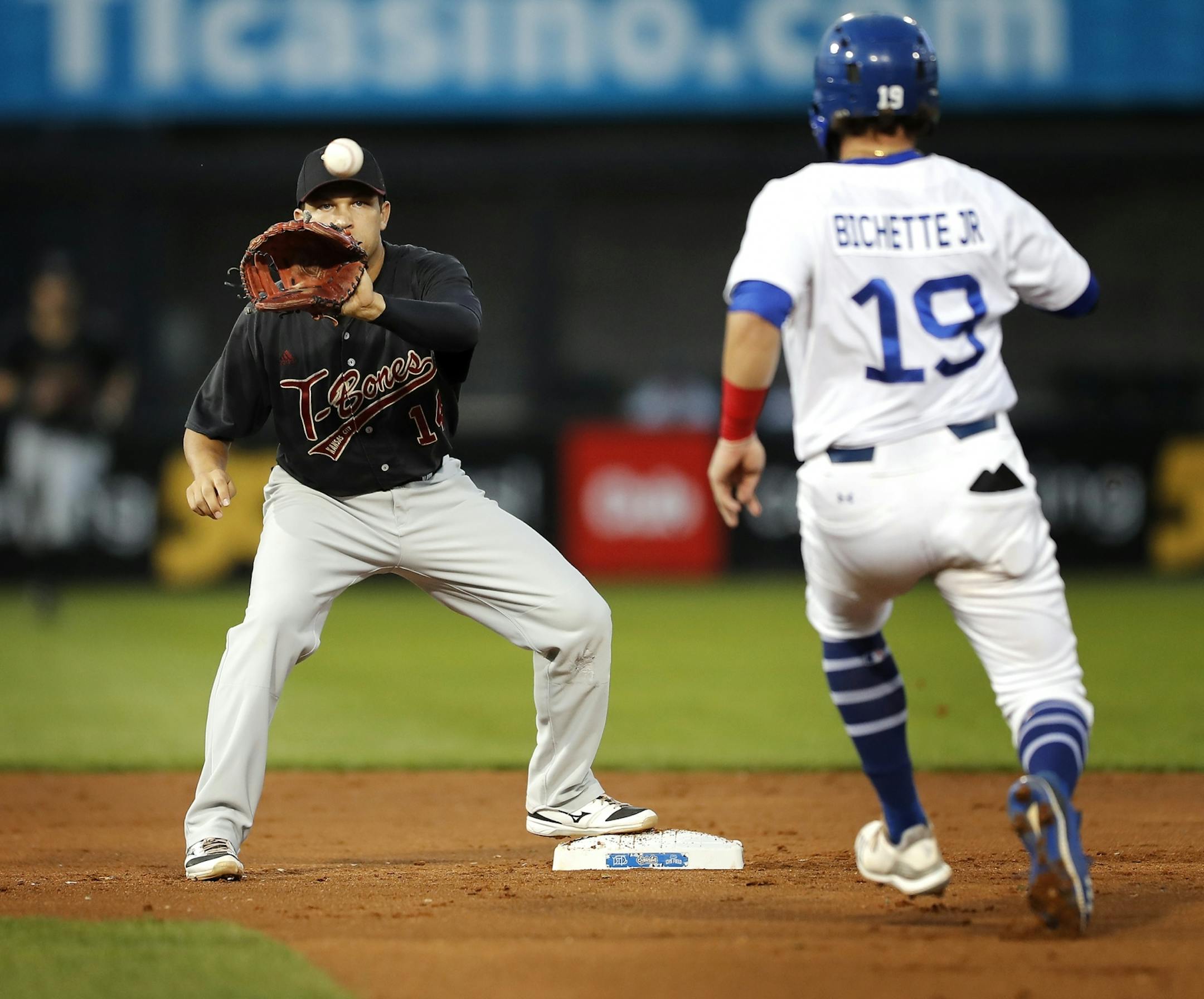 Saint Paul Saints third baseman Dante Bichette Jr. is tagged out at second base by Kansas City's Anthony Phillips.