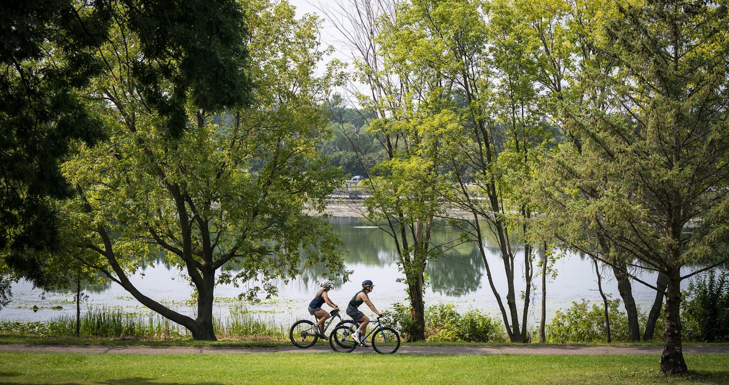 Bicyclists passed Wirth Lake at Theodore Wirth Park. ] LEILA NAVIDI • leila.navidi@startribune.com BACKGROUND INFORMATION: A warm and humid afternoon at Theodore Wirth Park in Minneapolis on Monday, August 24, 2020. Temperatures peaked in the high 80s today.