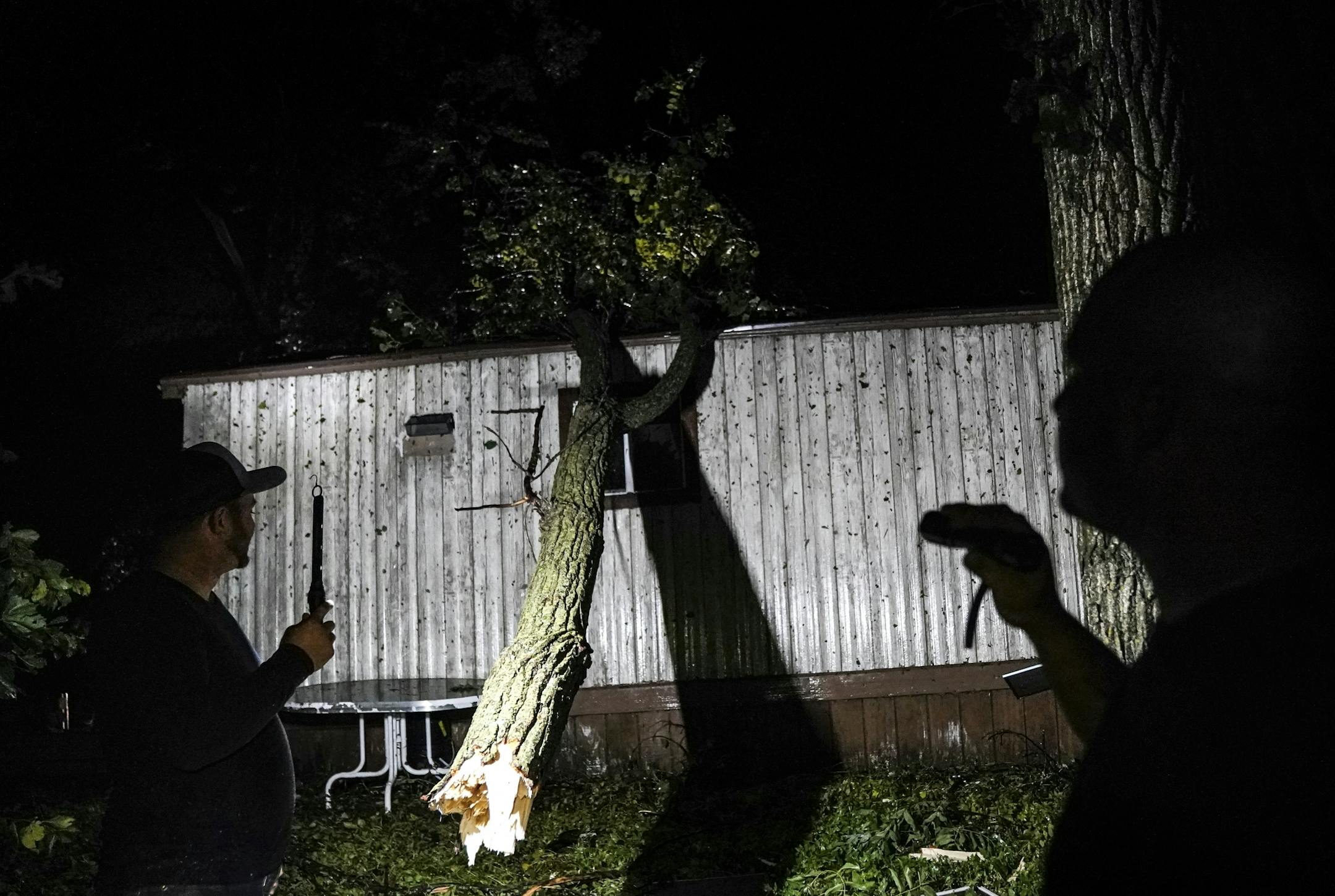 Lem Switzer, right, and Skyler Hansen surveyed the damage around Switzer's home following a reported tornado Thursday night in Northfield near Dundas.