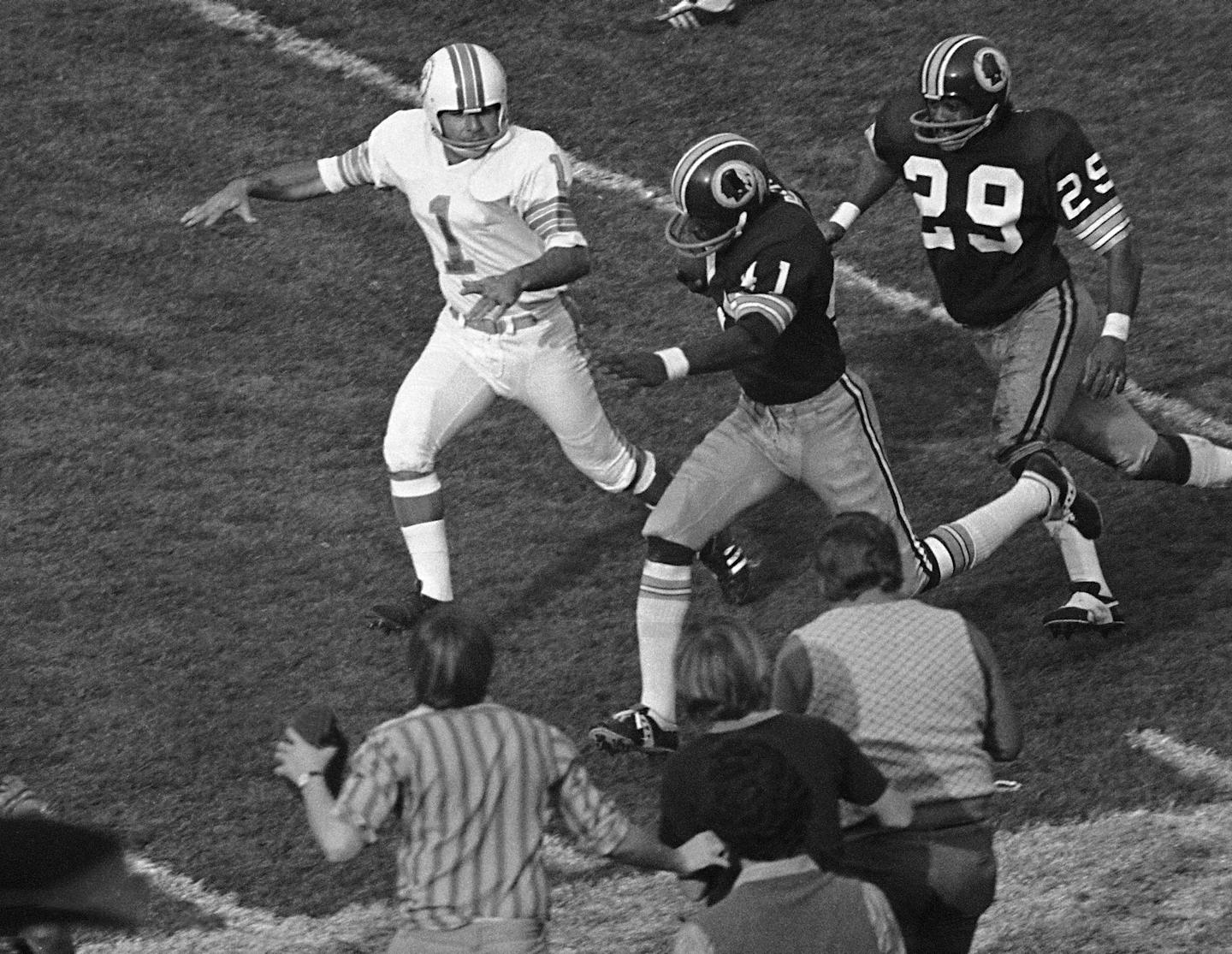 FILE - In this Jan. 14, 1973, file photo, Washington Redskins' Mike Bass (41) runs toward the end zone for the only Redskins score, during the fourth quarter of the NFL football Super Bowl against the Miami Dolphins in Los Angeles. Bass got the ball when field goal attempt by Dolphins' Garo Yepremian (1) was blocked and Yepremian attempted to pass. At right is Redskins' Ted Vactor. (AP Photo/File)