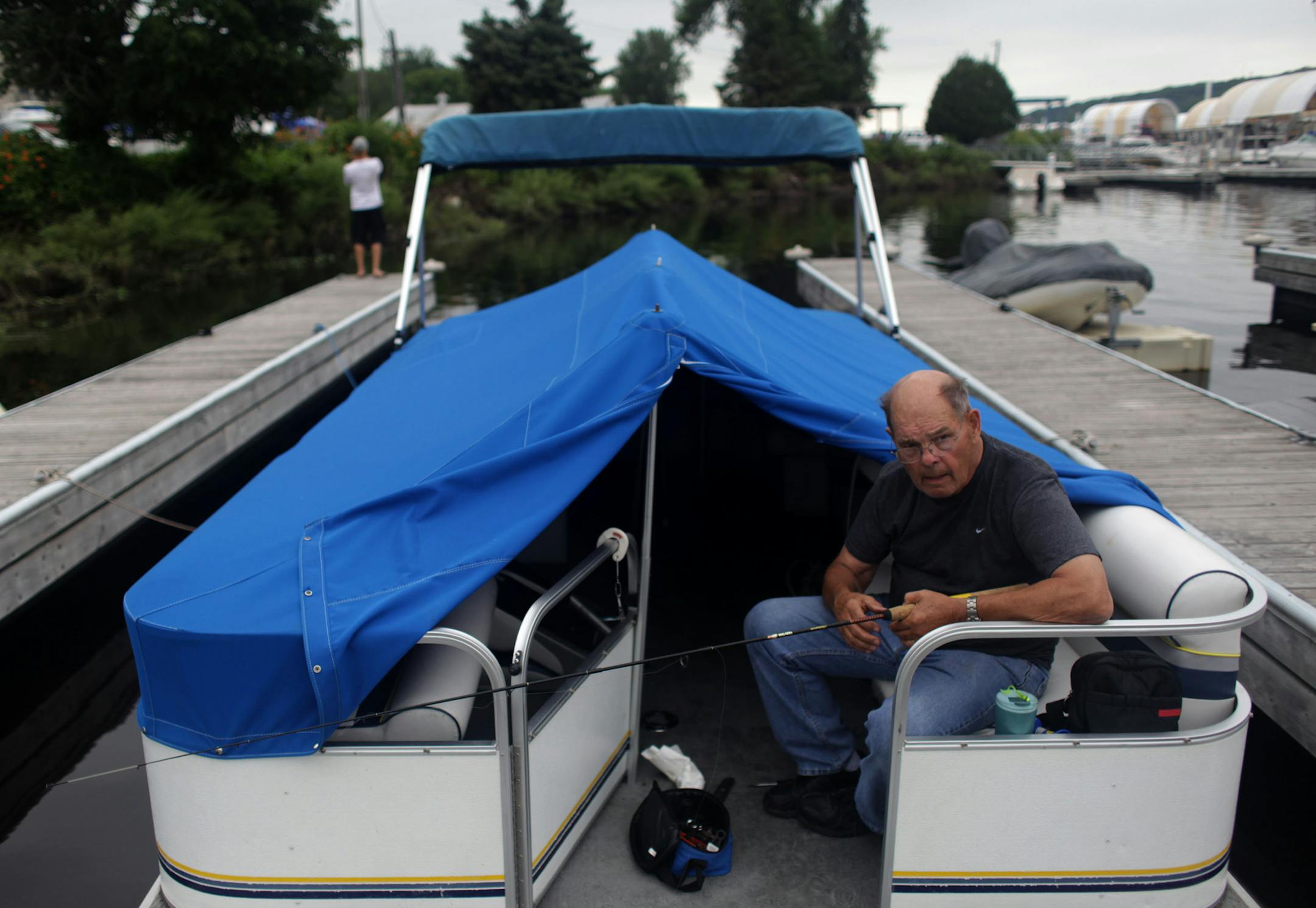 George Larson fixes his fishing pole on his boat on Friday afternoon at Sunnyside Marina on the St. Croix River. ] Activity returns to the Sunnyside Marina after the no-wake restrictions were lifted. MONICA HERNDON monica.herndon@startribune.com Stillwater, MN 07/11/14
