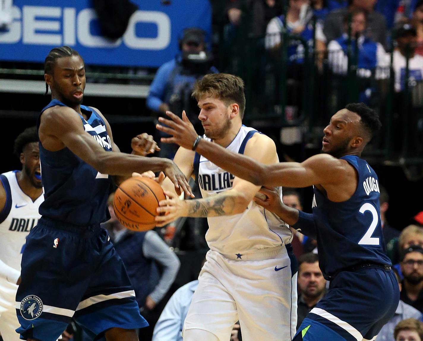 Minnesota Timberwolves' Andrew Wiggins (22) and Josh Okogie (20) guard Dallas Mavericks Luka Doncic (77)