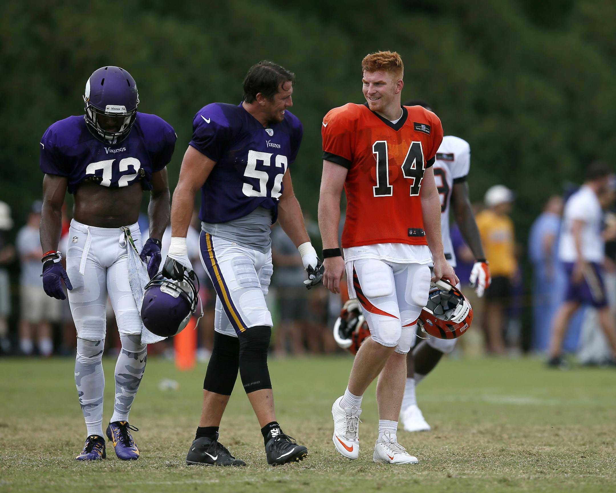 Minnesota Vikings outside linebacker Chad Greenway (52) and Cincinnati Bengals quarterback Andy Dalton (14) laugh as they walk between field during practice on Day 13 of training camp at the Paul Brown Stadium practice facility in downtown Cincinnati on Wednesday, Aug. 10, 2016. The Bengals and Vikings met on the practice field for the first of two joint practices ahead the first pre-season game of the year.