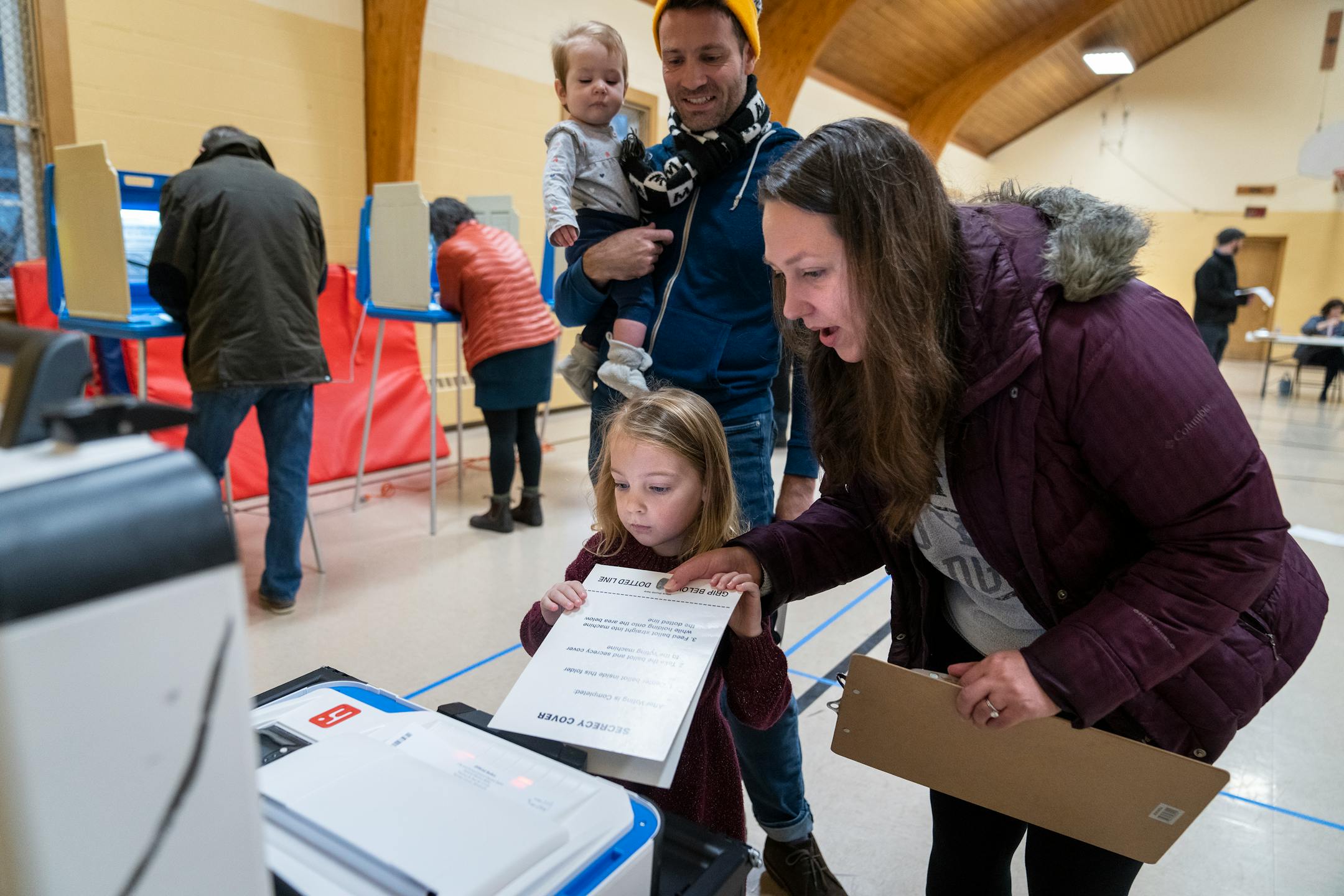 Margaret Citta, right, helps her daughter Imogen, 3, insert her ballot as husband Kyle holds their eight-month-old Beatrix behind them after voting at Gloria Dei Lutheran Church in Ward 3 of St. Paul on Election Day Tuesday, Nov. 7, 2023.