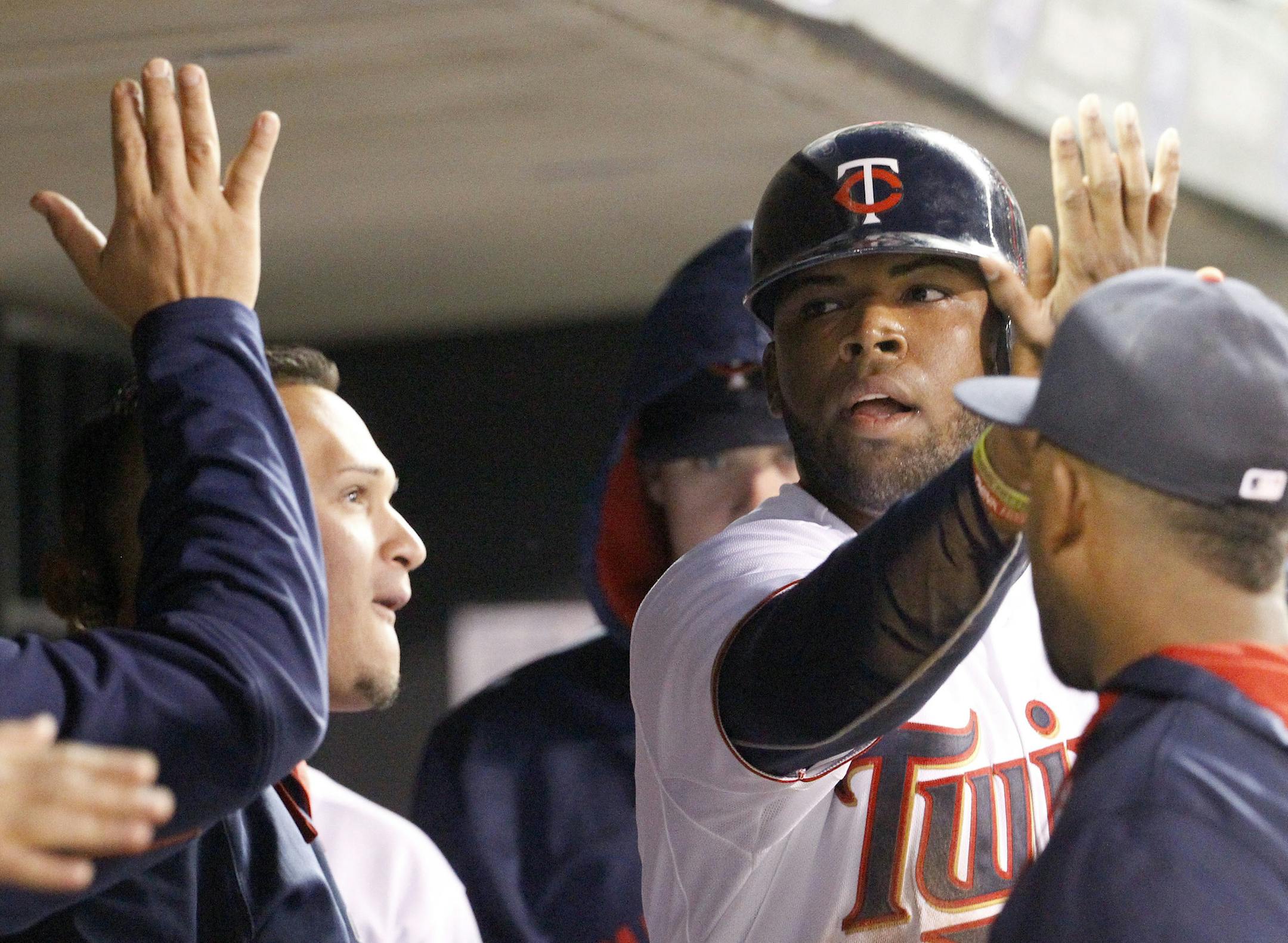 Minnesota Twins designated hitter Kennys Vargas celebrates with teammates in the dugout after scoring on a wild pitch by Chicago White Sox starting pitcher Jose Quintana during the fifth inning a baseball game in Minneapolis, Friday, May 1, 2015. (AP Photo/Ann Heisenfelt)