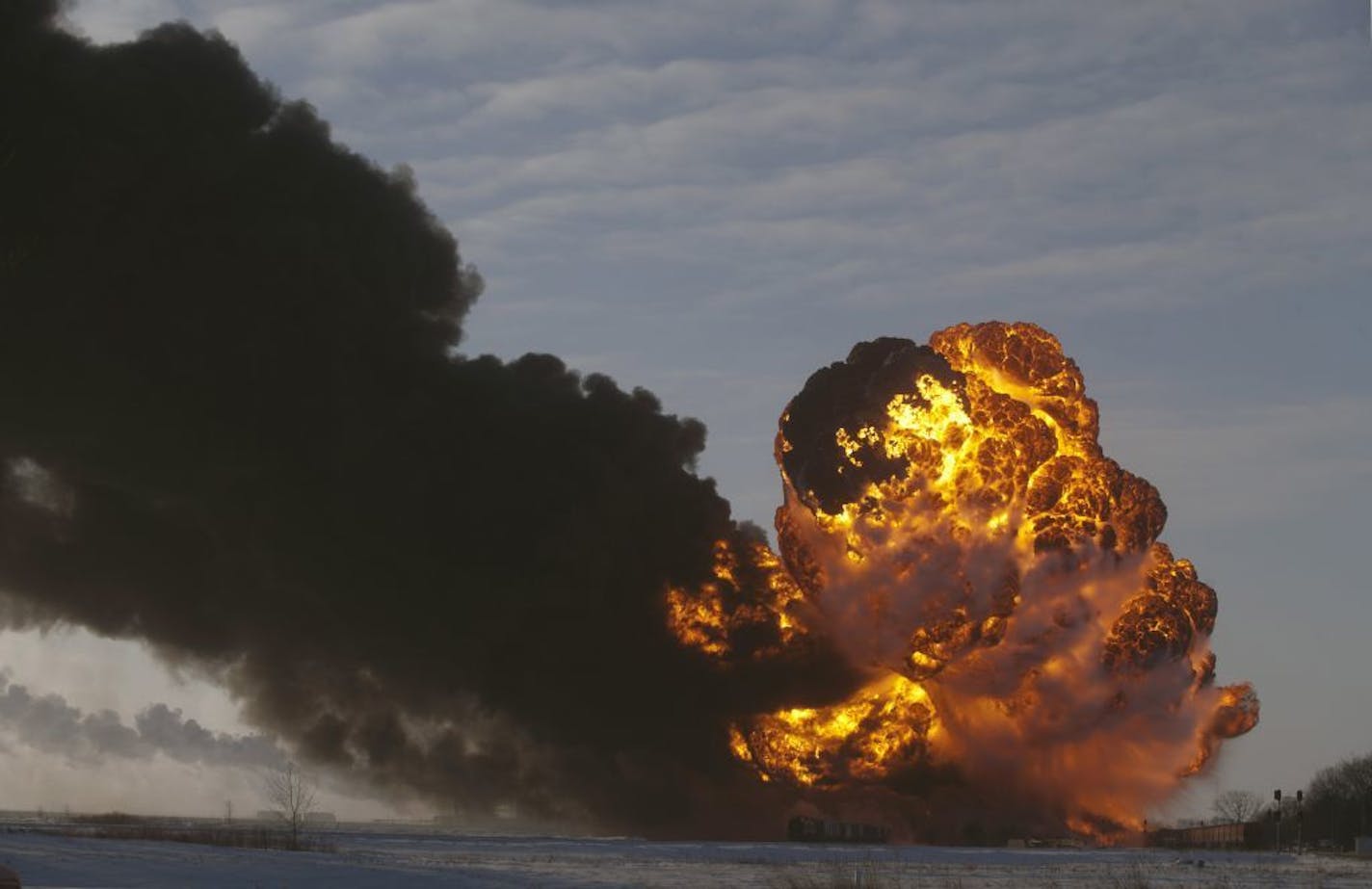 FILE - In this Dec. 30, 2013 file photo, a fireball goes up at the site of an oil train derailment in Casselton, N.D. North Dakota's Industrial Commission is considering new rules that could require oil companies to reduce the volatility of crude before it's loaded onto rail cars. The Department of Mineral Resources is slated to make a proposal Thursday, Nov. 13, 2014, that may require companies to remove certain liquids and gasses from oil train shipments, a process some say would make such tra