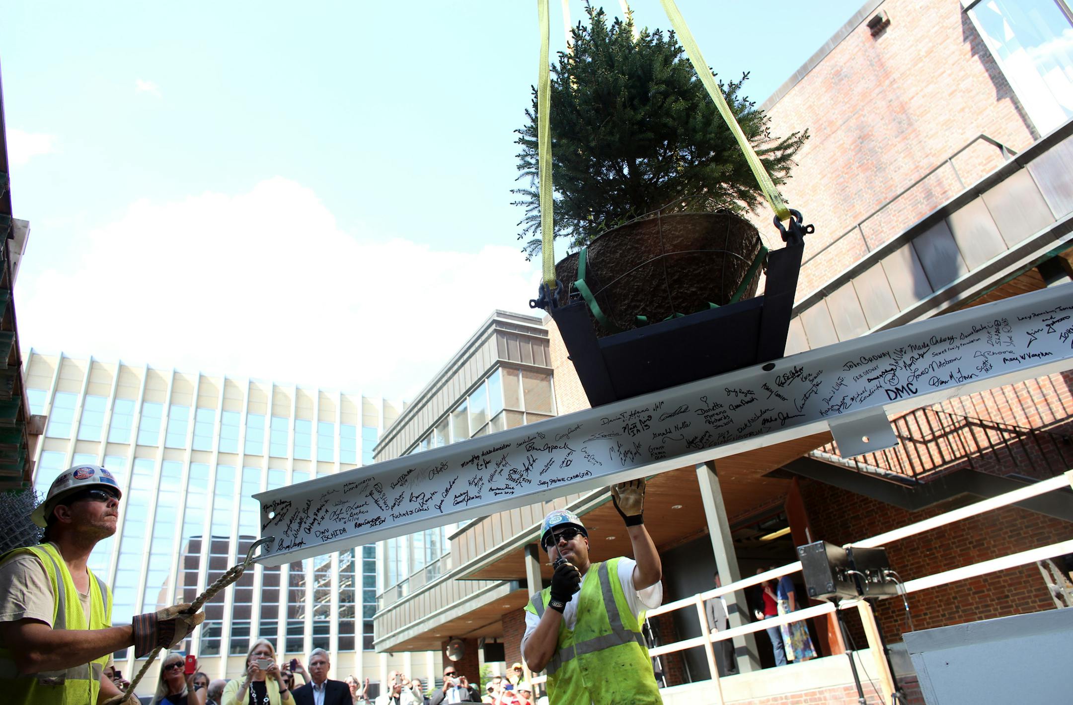 A beam-raising ceremony was held at the new concert hall at the Ordway Center in St. Paul on Wednesday. David Synder, left, and Doug Sexton, of Ironworkers Local 512, guided the beam as it was put into place. The pine tree atop the beam is a Scandinavian tradition to bring good luck to the building.