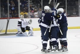 Union goalie Alex Sakellaropoulos, left, stands up as Penn State's Chase Berger and his teammates celebrate his goal during the first period in the re