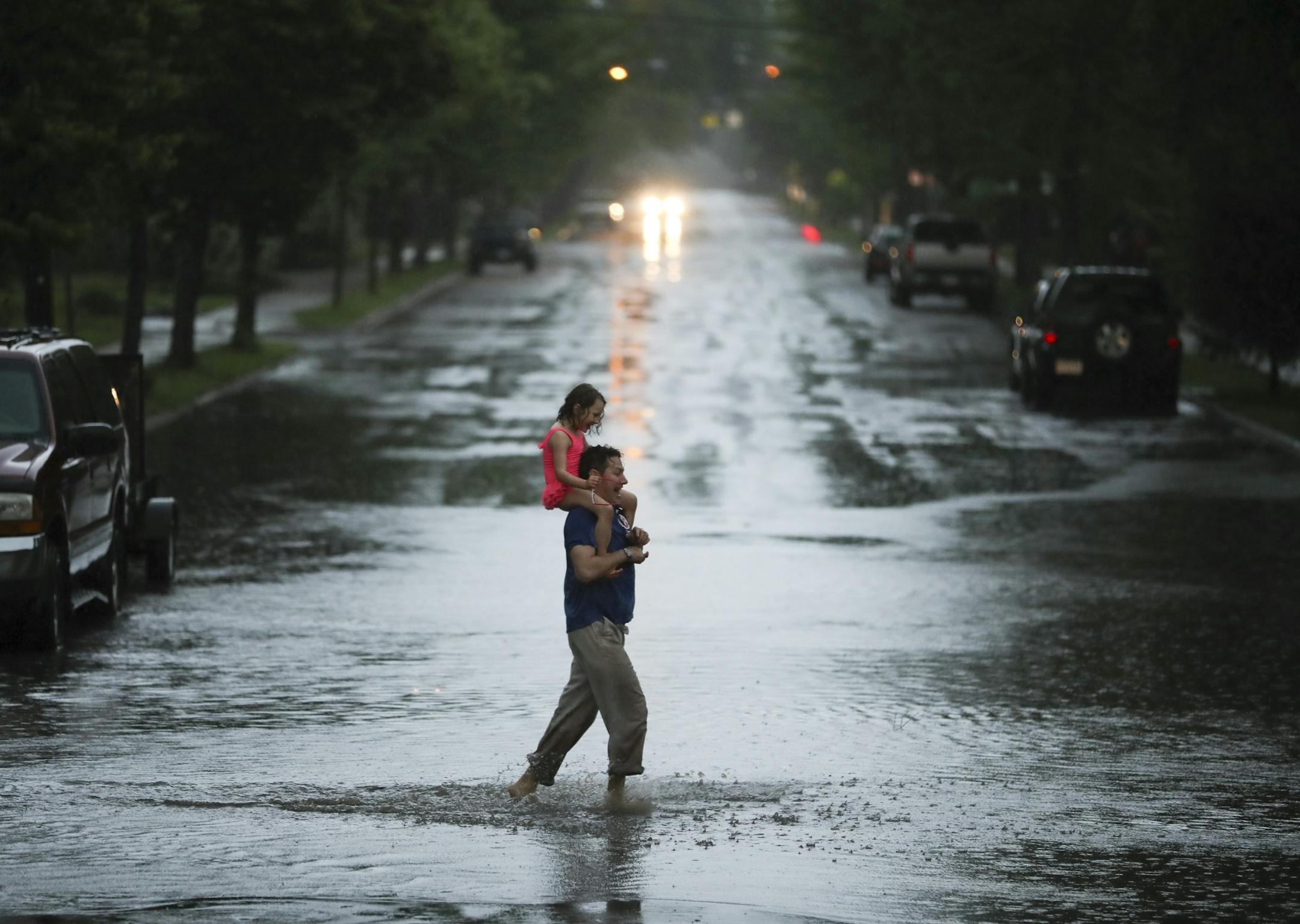 John Franke and his daughter, Esme, explored the huge puddle at the intersection of E. 42nd St. at 38th Ave. S. Wednesday evening. Esme.