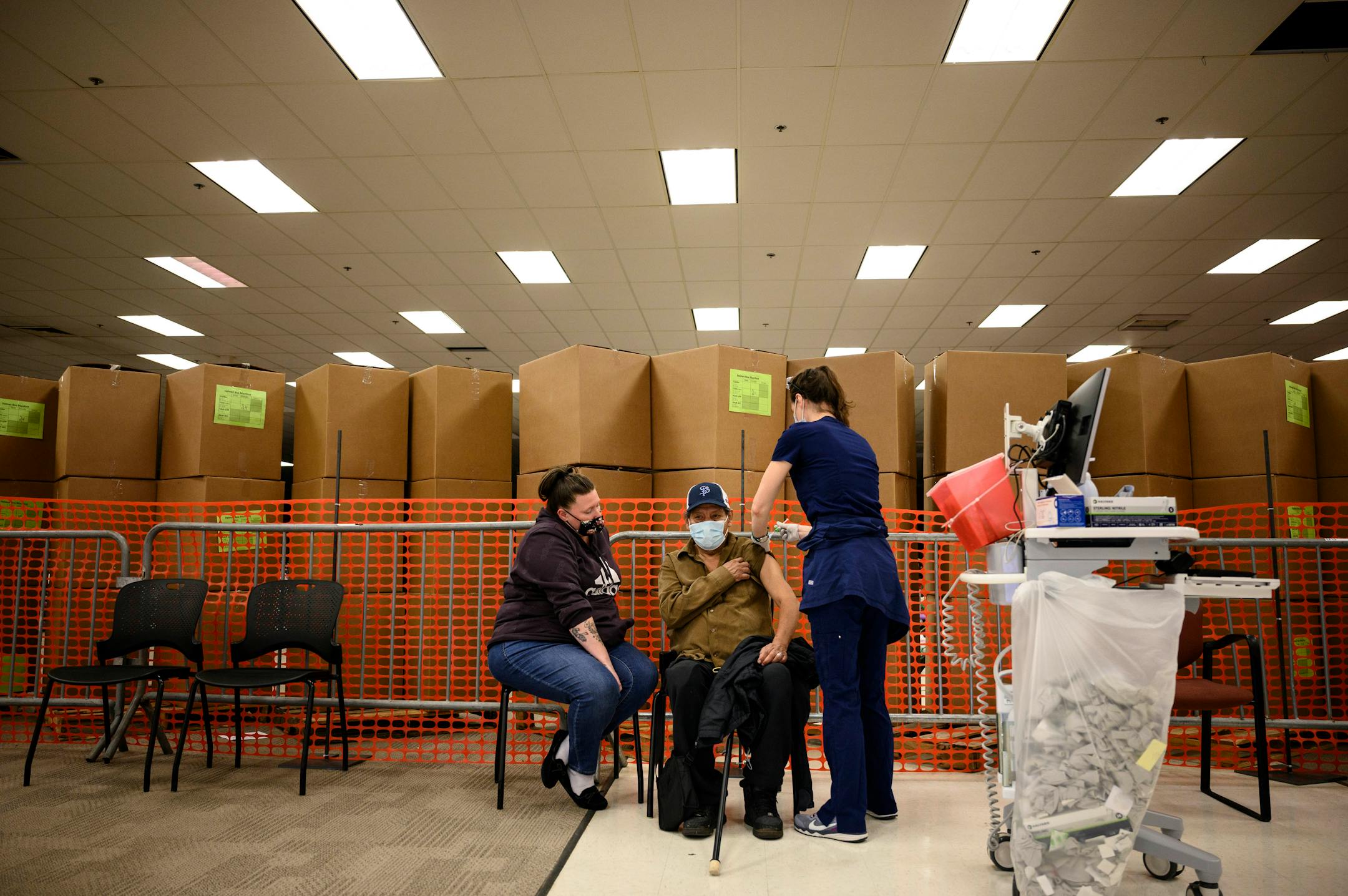 Cassandra Mendez watched as her father-in-law, Alvaro Mendez, 70, was given a dose of the Moderna COVID-19 vaccine by nurse Elizabeth Turner Tuesday afternoon at North Memorial Health Hospital's Brooklyn Center vaccination clinic.