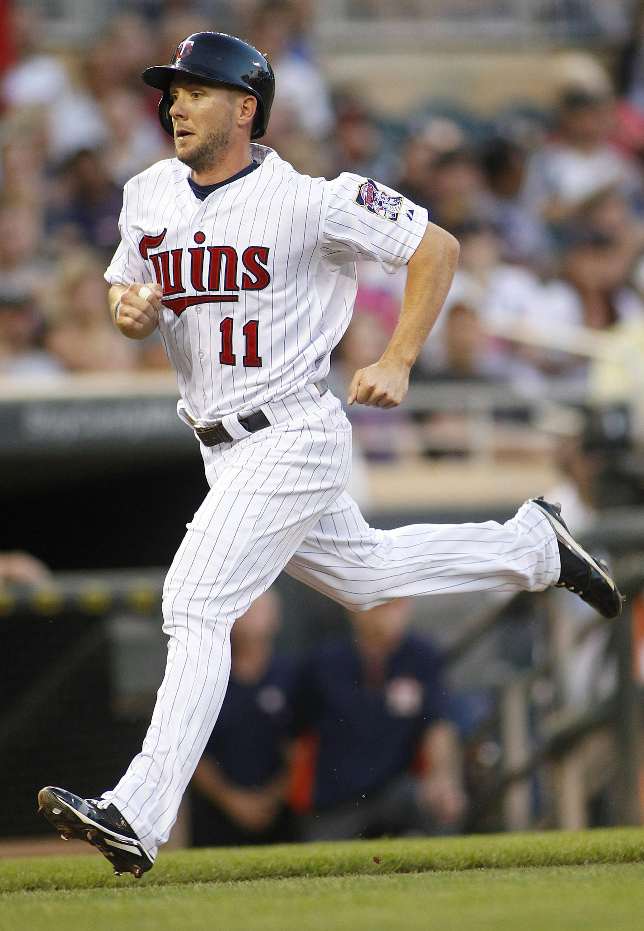 Minnesota Twins Clete Thomas scores on a sacrifice fly ball hit by the Twins Joe Mauer against the Houston Astros in the third inning of their baseball game in Minneapolis Friday, Aug. 2, 2013.(AP Photo/Andy Clayton-King)