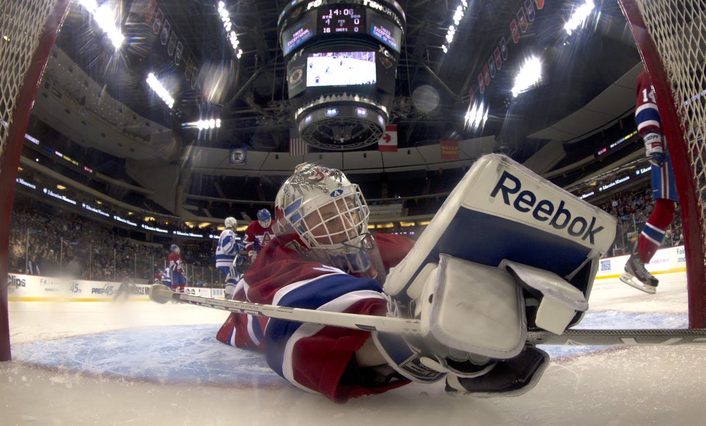 St. Cloud Apollo goalie Nick Althaus (32) could not stop a shot by Wyatt Schmidt (4) of St. Thomas Academy for a goal in the second period. STA beat St. Cloud Apollo by a final score of 12-0. ] CARLOS GONZALEZ cgonzalez@startribune.com - March 6, 2013, St. Paul, Minn., Xcel Energy Center, Minnesota High School Boys State Hockey Tournament, St. Cloud Apollo vs. St. Thomas Academy
